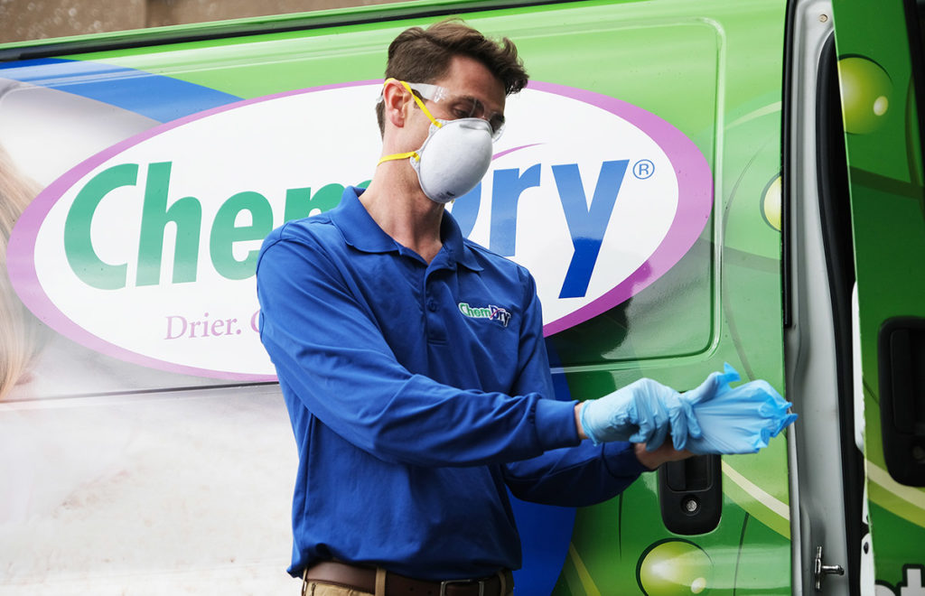 Buy a carpet cleaning franchise with Chem-Dry Franchise man puts on gloves outside Chem-Dry truck